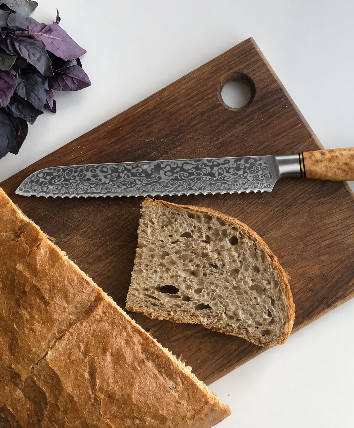 Couteau à pain Signature avec pain de campagne sur une planche en bois